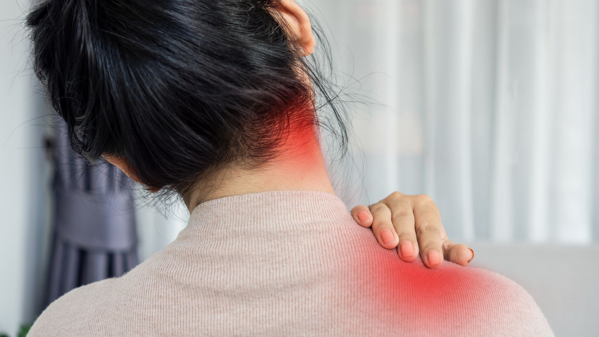 woman grabbing her shoulder and neck
